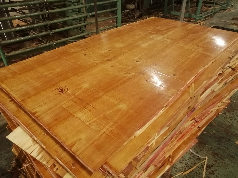 Glossy wooden board stacked in a factory setting with green machinery in the background, warm brown tones, industrial mood